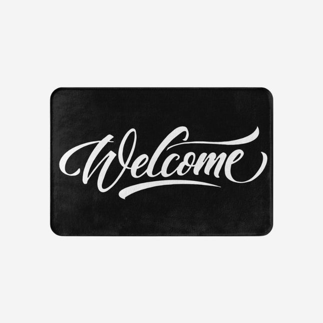 Svart dörrmatta med 'Welcome' i skrivstil