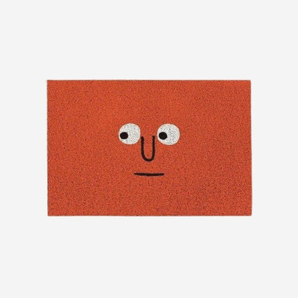Röd dörrmatta med roligt ansikte