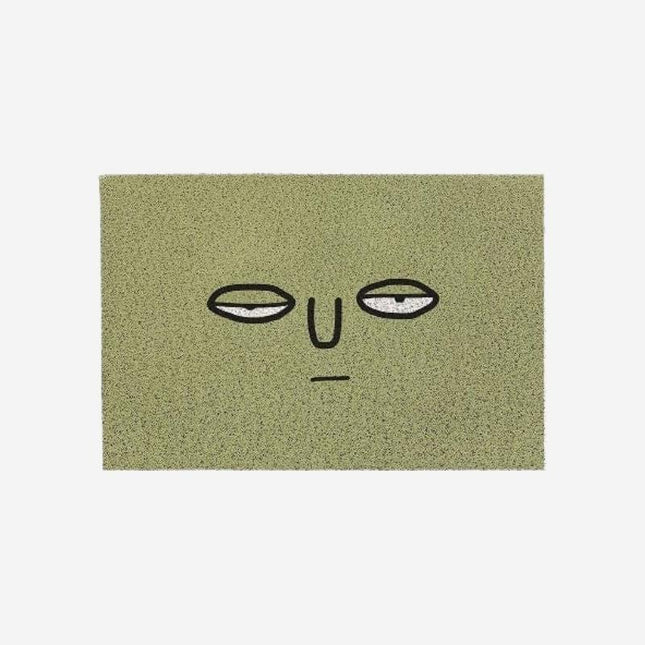 Grön dörrmatta med roligt ansikte
