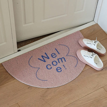 Halvmåneformad dörrmatta med 'Welcome' text