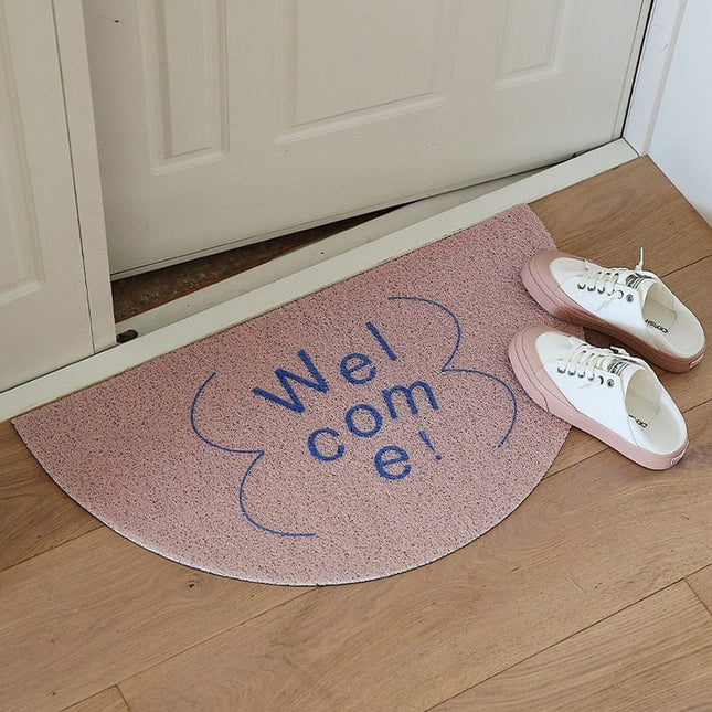 Halvmåneformad dörrmatta med 'Welcome' text