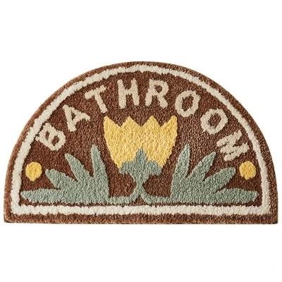 Gul halvcirkelformad badrumsmatta med blommor